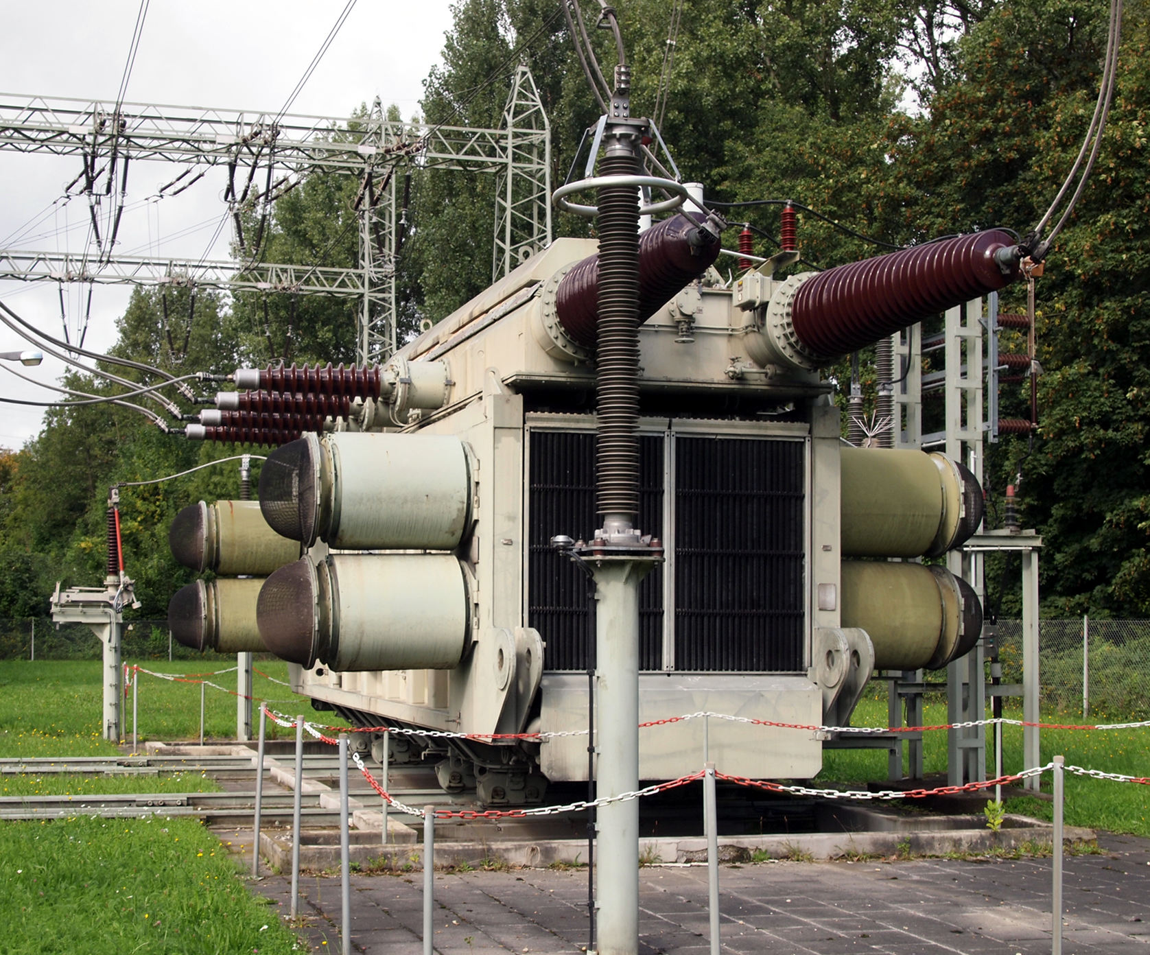 220 kV 室外油浸式電力變壓器，可見高壓套管、避雷器、散熱器與強制風冷風扇